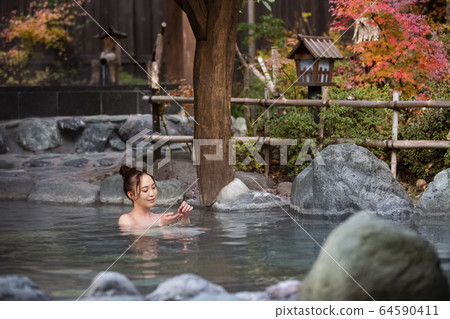 Woman enjoying a hot spring trip 64590411