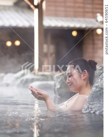 A woman enjoying an open-air bath A woman enjoying an open-air bath 64590651