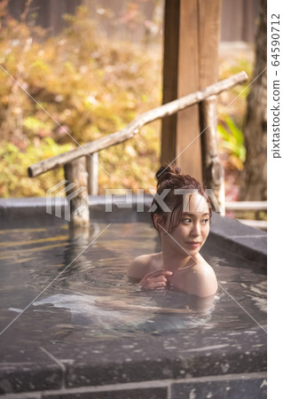 Woman enjoying a hot spring trip Woman enjoying a hot spring trip 64590712