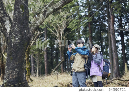 Couple taking pictures in the mountains Couple taking pictures in the mountains 64590721