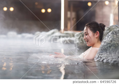 A woman enjoying an open-air bath A woman enjoying an open-air bath 64590726