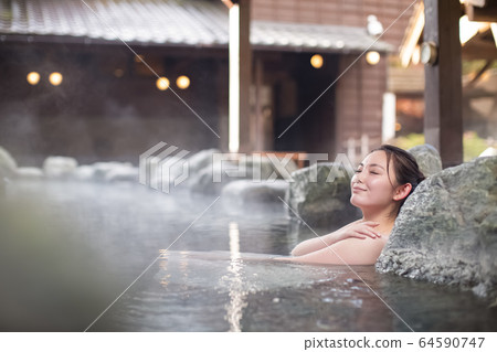 A woman enjoying an open-air bath A woman enjoying an open-air bath 64590747