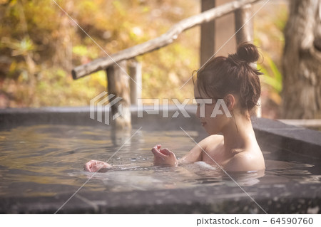 Woman enjoying a hot spring trip Woman enjoying a hot spring trip 64590760