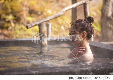 Woman enjoying a hot spring trip Woman enjoying a hot spring trip 64590839