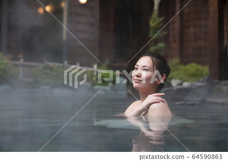 A woman enjoying an open-air bath A woman enjoying an open-air bath 64590863