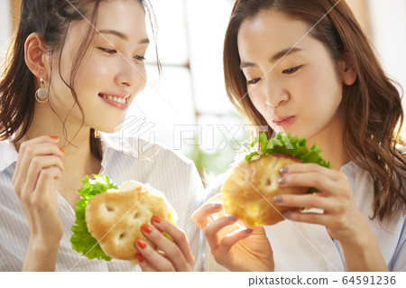 Woman enjoying a meal with friends Woman enjoying a meal with friends 64591236