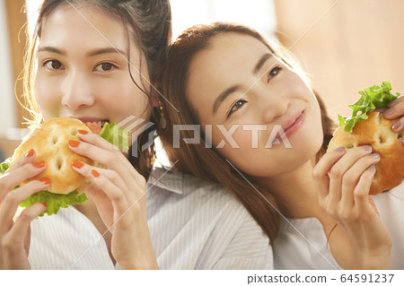 Woman enjoying a meal with friends 64591237