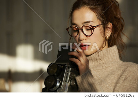 A woman taking a picture with a camera A woman taking a picture with a camera 64591262