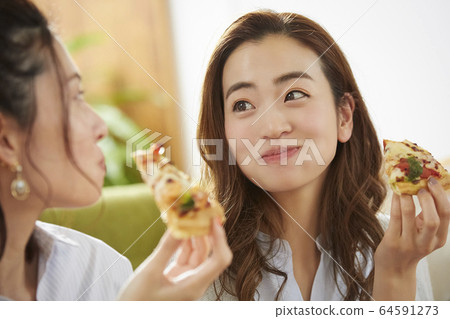 Woman having a home party with her friends 64591273