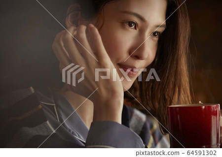 A woman drinking coffee 64591302