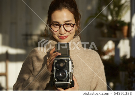A woman taking a picture with a camera 64591388