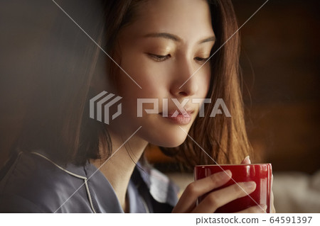 A woman drinking coffee 64591397