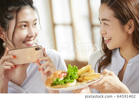 Woman enjoying a meal with friends Woman enjoying a meal with friends 64591402