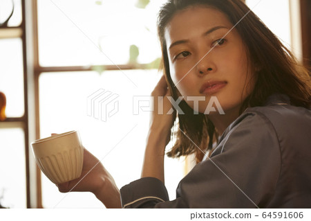 A woman relaxing in the bedroom 64591606