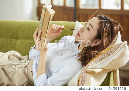 Woman relaxing in the living room 64591616