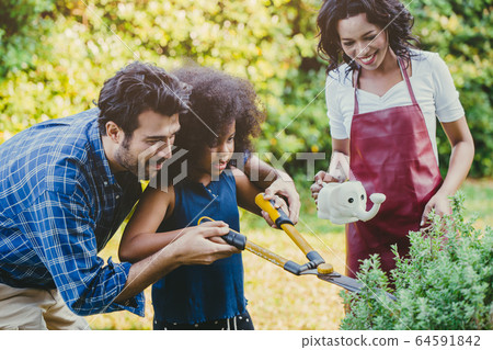 Family lovely gardening backyard watering green plant activity with children during Stay at Home 64591842