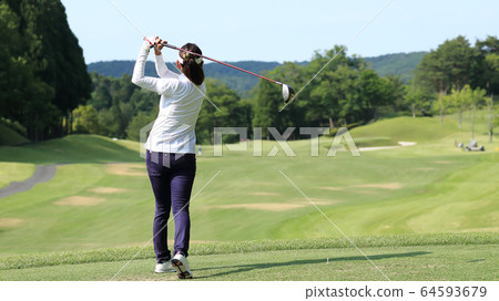 Woman hitting the tee shot Woman hitting the tee shot 64593679