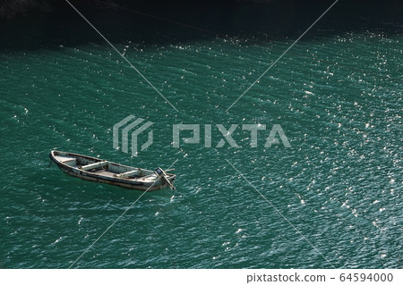 A small boat floating on the lake 64594000