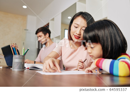 Mother helping daughter with drawing 64595337