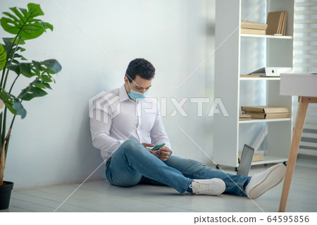 Man sitting on the floor and looking demotivated Man sitting on the floor and looking demotivated 64595856