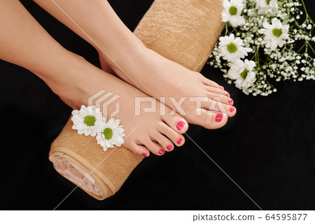 Manicured feet on rolled towel 64595877