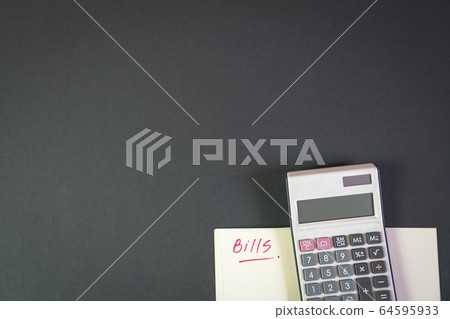 Bills. Notepad with calculator on top of black Bills. Notepad with calculator on top of black 64595933