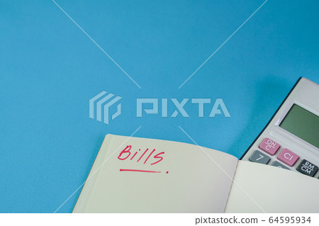 Bills. Notepad with calculator on top of blue 64595934