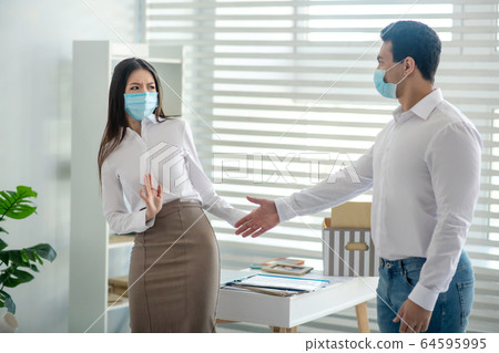 Young woman in a protective mask fstepping aside 64595995