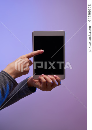 Close-up of human's hands with smartphone and black screen on purple background 64599698