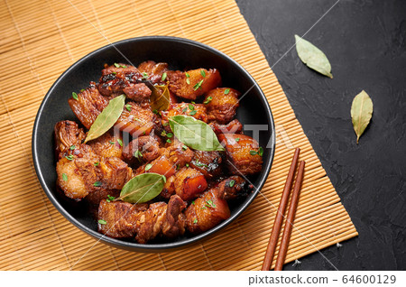 Adobo Pork in black bowl at black dark background. filipino food 64600129