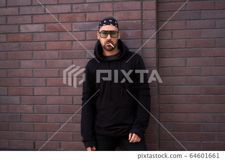 Handsome young unshaven man black hoodie and Handsome young unshaven man black hoodie and 64601661