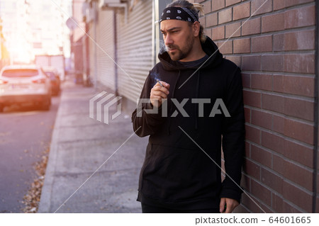 Handsome young unshaven man black hoodie and Handsome young unshaven man black hoodie and 64601665