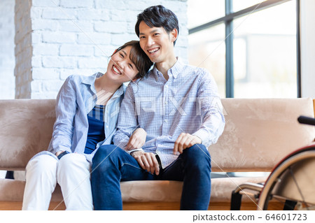 輪椅男人和女人對年輕的夫婦 輪椅男人和女人對年輕的夫婦 64601723