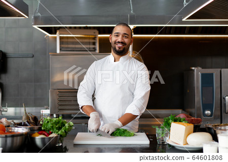 Handsome young African chef standing in 64601808