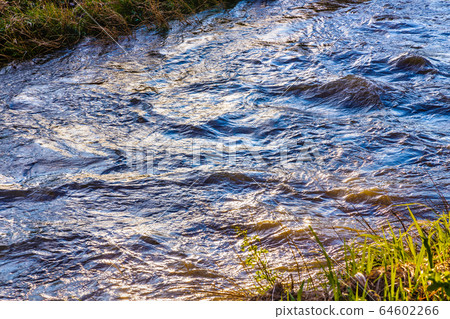 日落時河與豐富的水流動 日落時河與豐富的水流動 64602266