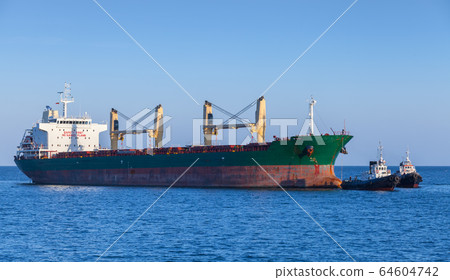 Bulk carrier and a tug boat are on the way 64604742