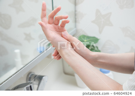 Women painting hand cream 64604924