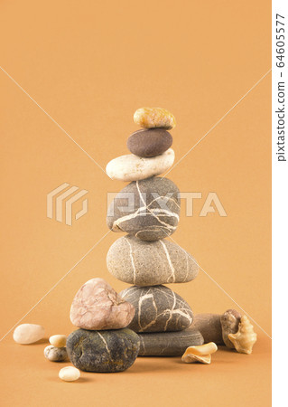 Tower of sea natural stones on a brown background. Tower of sea natural stones on a brown background. 64605577