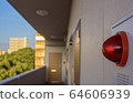 A close up of a red warning light in front of an apartment building in Japan. 64606939