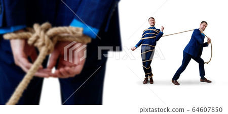 Angry businessman pulls tied himself with a rope. 64607850