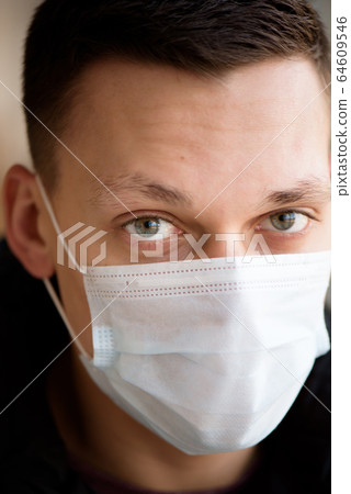 Portrait of a young guy in a protective face mask. New coronavirus (2019-nKoV) infection Portrait of a young guy in a protective face mask. New coronavirus (2019-nKoV) infection 64609546