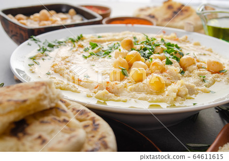 Closeup view at Hummus topped with beans olive oil Closeup view at Hummus topped with beans olive oil 64611615