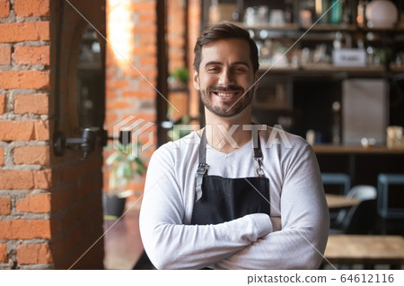 Happy confident young waiter entrepreneur looking at camera, portrait 64612116