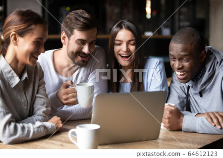 Happy multiracial friends watching funny comedy in cafe on laptop Happy multiracial friends watching funny comedy in cafe on laptop 64612123