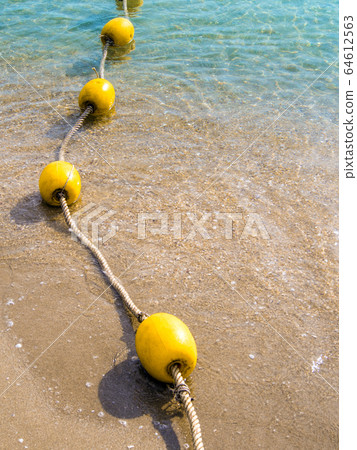 Floating buoy and rope dividing the area on the beach Floating buoy and rope dividing the area on the beach 64612563