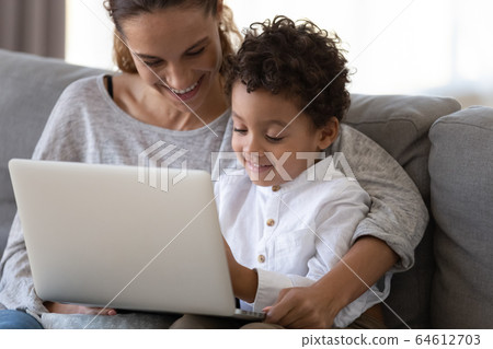 Happy mother embrace african cute kid son learning using laptop Happy mother embrace african cute kid son learning using laptop 64612703