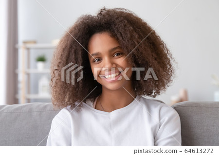 Headshot of smiling african girl looking at camera at home 64613272