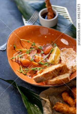 Sliced salmon with toast and dressing on stone background Sliced salmon with toast and dressing on stone background 64613673