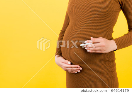 Close up of pregnant woman in brown dress with a 64614179