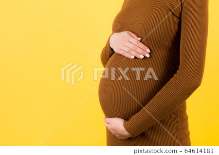 Cropped image of pregnant woman in brown dress Cropped image of pregnant woman in brown dress 64614181
